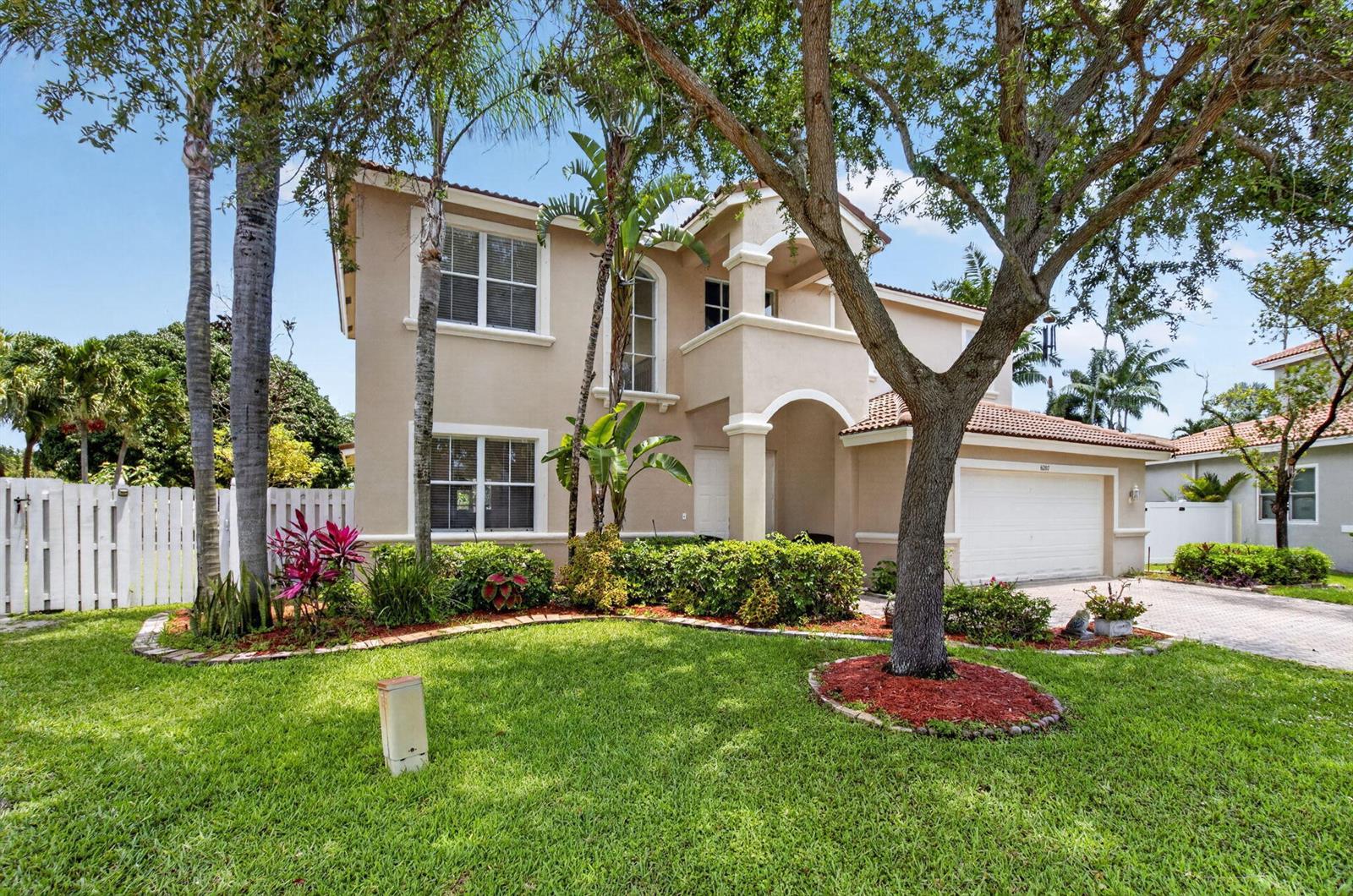 A two-story beige house with a tiled roof, a two-car garage, and a front lawn — 6207 Shadow Tree Lane, Lake Worth FL 33463, LAKE WORTH, FL