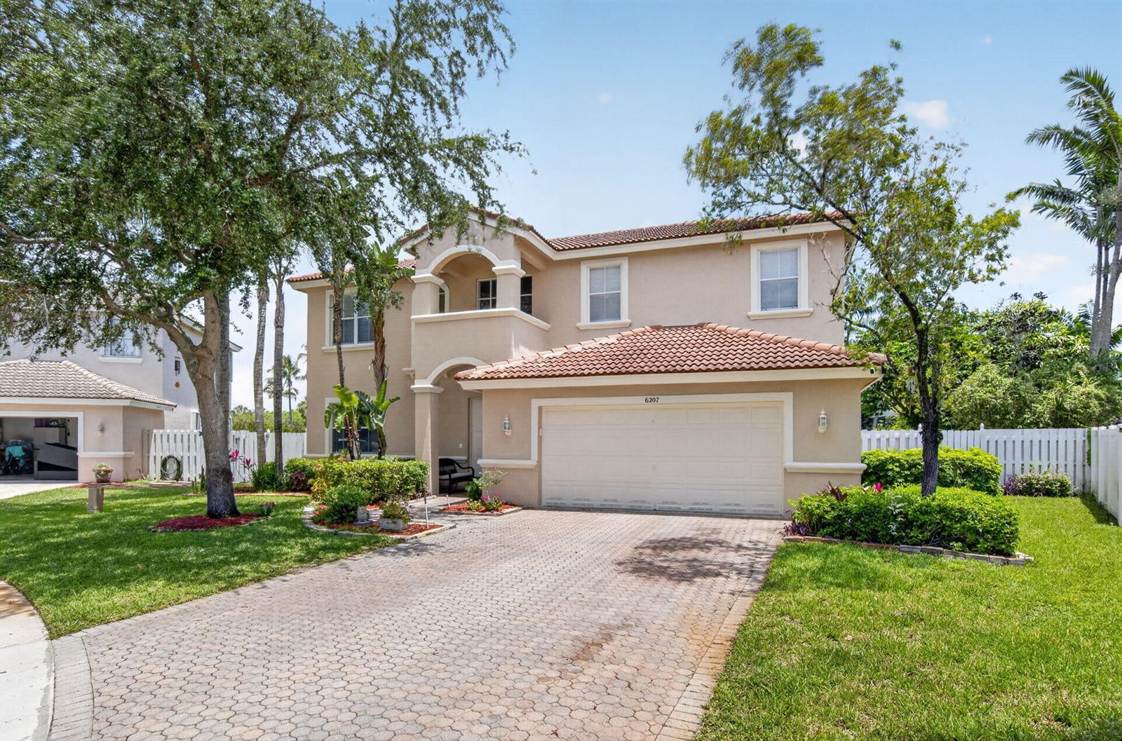 A two-story beige house with a tiled roof, a two-car garage, and a paved driveway — 6207 Shadow Tree Lane, Lake Worth FL 33463, LAKE WORTH, FL