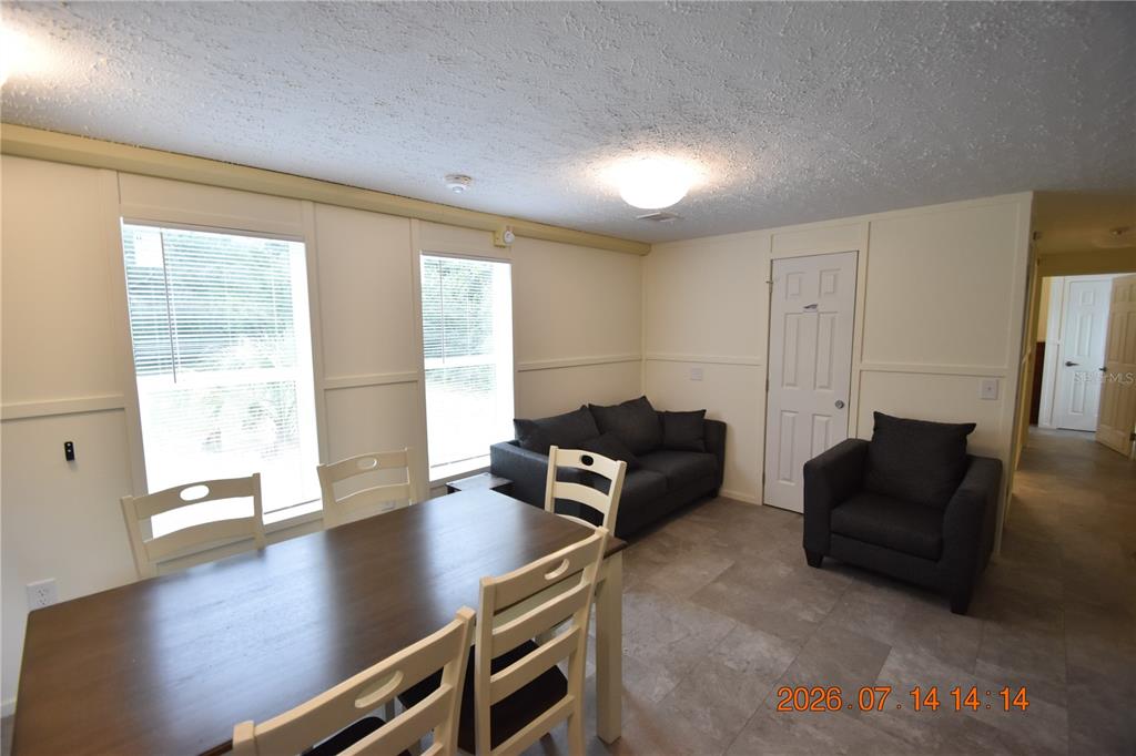 A dining area with a wooden table and chairs sits adjacent to a living space — 6560 W AVOCADO STREET, CRYSTAL RIVER, FL