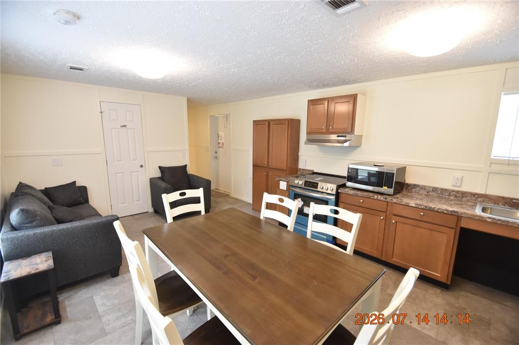 A kitchen and dining area features light-colored walls, wood cabinets, and a dark dining table — 6560 W AVOCADO STREET, CRYSTAL RIVER, FL
