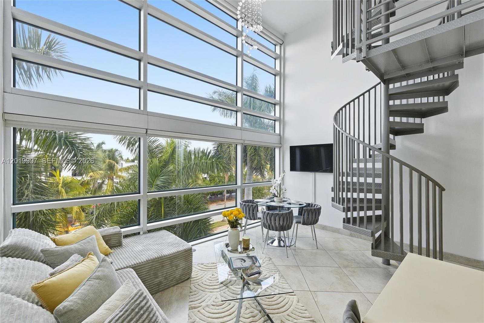 A living room features floor-to-ceiling windows, a spiral staircase, and a dining area — 421 Meridian Ave # 16, Miami Beach FL 33139, MIAMI BEACH, FL