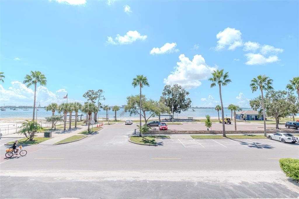 An outdoor view of a parking lot, palm trees, and a beach along the water — 5605 SHORE BOULEVARD S UNIT 1B, GULFPORT, FL