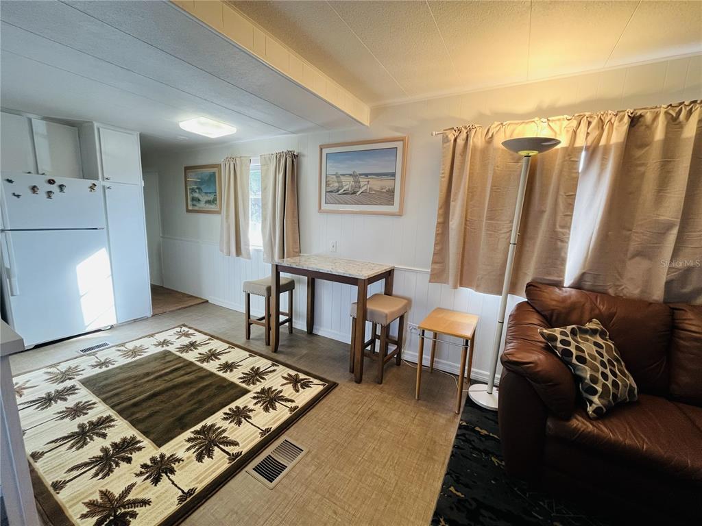 A living area features a kitchen corner, a dining table with stools, and a sofa — 2113 ILLINOIS AVENUE, BRADENTON, FL