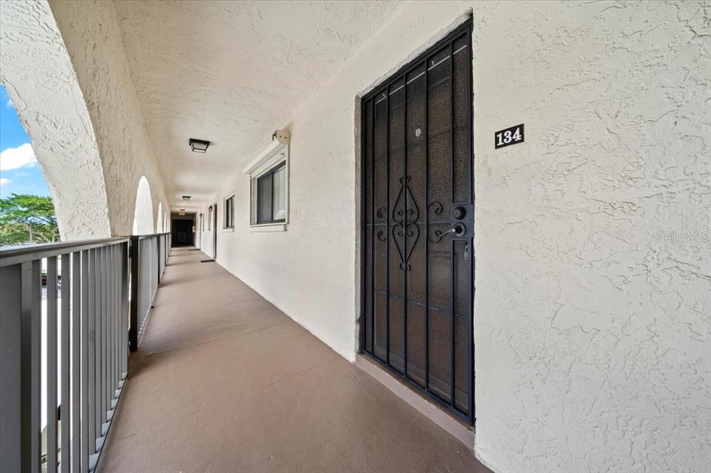 An exterior walkway with a metal railing leads to a door marked 134 — 5800 N BANANA RIVER BOULEVARD UNIT 134, CAPE CANAVERAL, FL