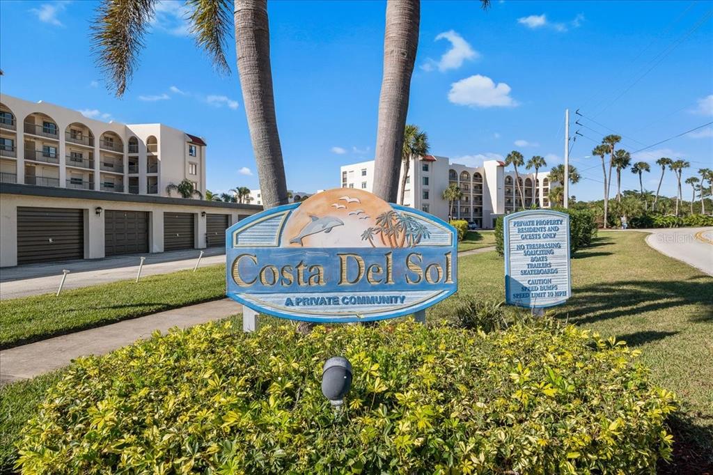 A sign for the Costa Del Sol community stands before apartment buildings and palm trees — 5800 N BANANA RIVER BOULEVARD UNIT 134, CAPE CANAVERAL, FL