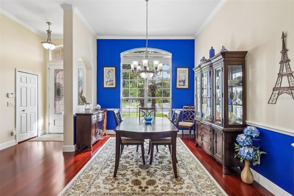 A dining room features a blue accent wall, a wooden table, and a large china cabinet — 115 W BLUE WATER EDGE DRIVE, EUSTIS, FL