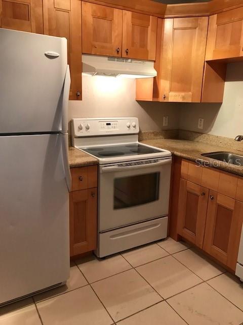 A kitchen features light wood cabinets, a white refrigerator, and a white electric range — 3914 W NEPTUNE STREET UNIT 13, TAMPA, FL