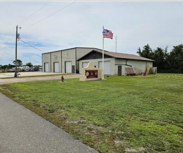 A fire station building with a large lawn, a flagpole, and a paved driveway — 1312 COLUMBUS STREET, LAKE PLACID, FL