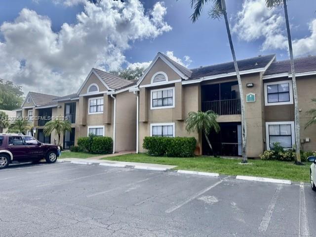 A two-story apartment building with tan stucco siding and a dark shingled roof — 10670 SW 156th Pl # 301, Miami FL 33196, MIAMI, FL