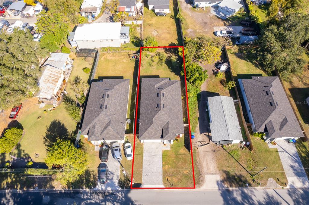 An aerial view shows a single-family house with a paved driveway and a fenced backyard — 1519 INDIANA STREET, ORLANDO, FL