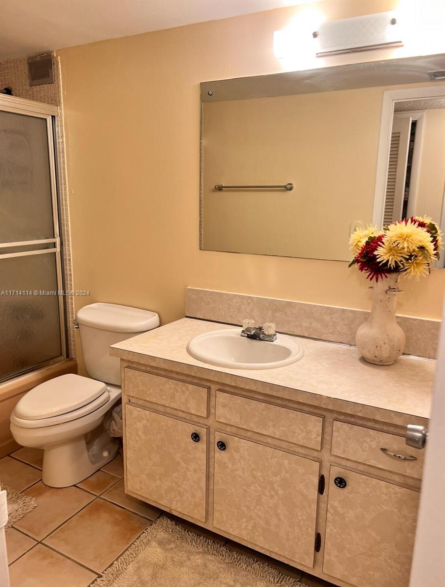 A bathroom features a vanity with a beige countertop, a toilet, and a shower stall — 1410 S Ocean Dr # 804, Hollywood FL 33019, HOLLYWOOD, FL