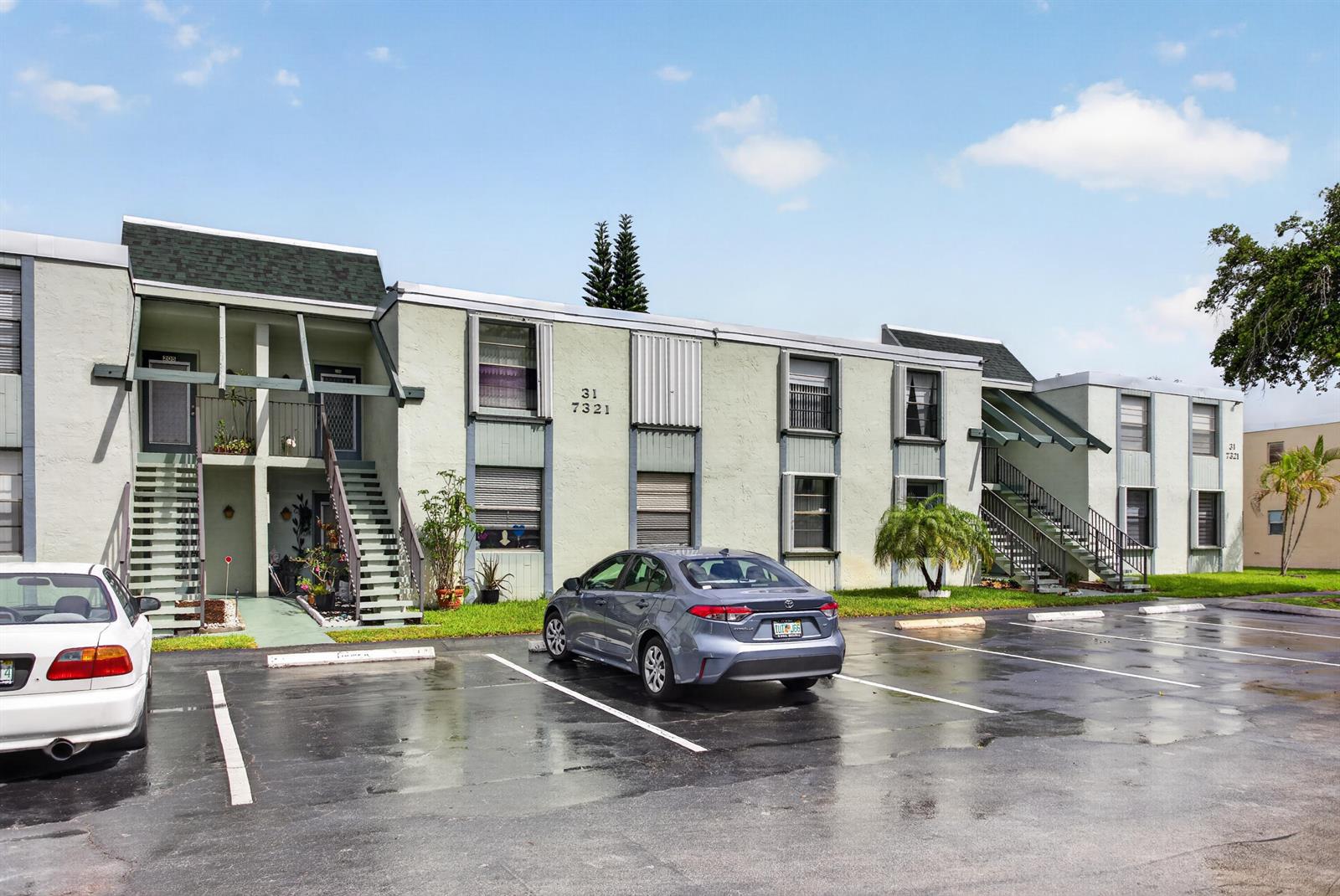 A two-story apartment building with a parking lot and two cars in front — 7321 NW 18th Street # 107, Margate FL 33063, MARGATE, FL