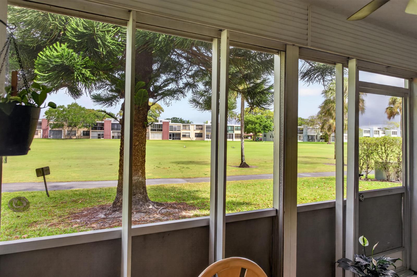 A view of a golf course and apartment buildings from a screened-in porch — 7321 NW 18th Street # 107, Margate FL 33063, MARGATE, FL