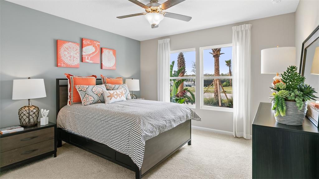 A bedroom features a bed with orange accents, a ceiling fan, and a window view — 32 HARDWOOD TRAIL, PALM COAST, FL