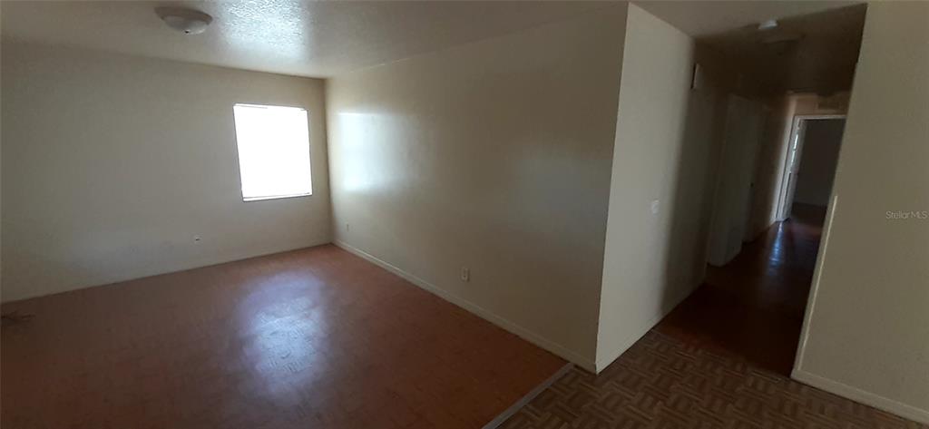 An empty room with light-colored walls, a single window, and wood-look flooring — 4226 E PALIFOX STREET, TAMPA, FL