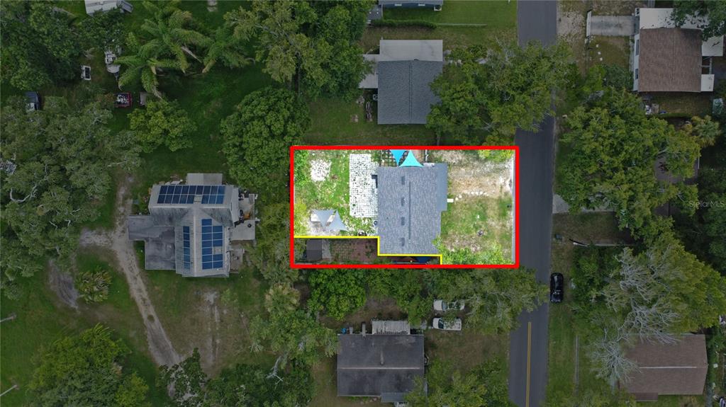 An aerial view shows a house with a gray roof surrounded by trees and grass — 126 PALM DRIVE, DAYTONA BEACH, FL