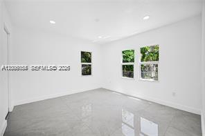 An empty room with white walls, recessed lighting, and light-colored tile flooring — 1301 Sharar Ave, Opa-Locka FL 33054, OPA-LOCKA, FL