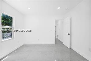 An empty room with white walls, gray tile flooring, and a single window — 1301 Sharar Ave, Opa-Locka FL 33054, OPA-LOCKA, FL
