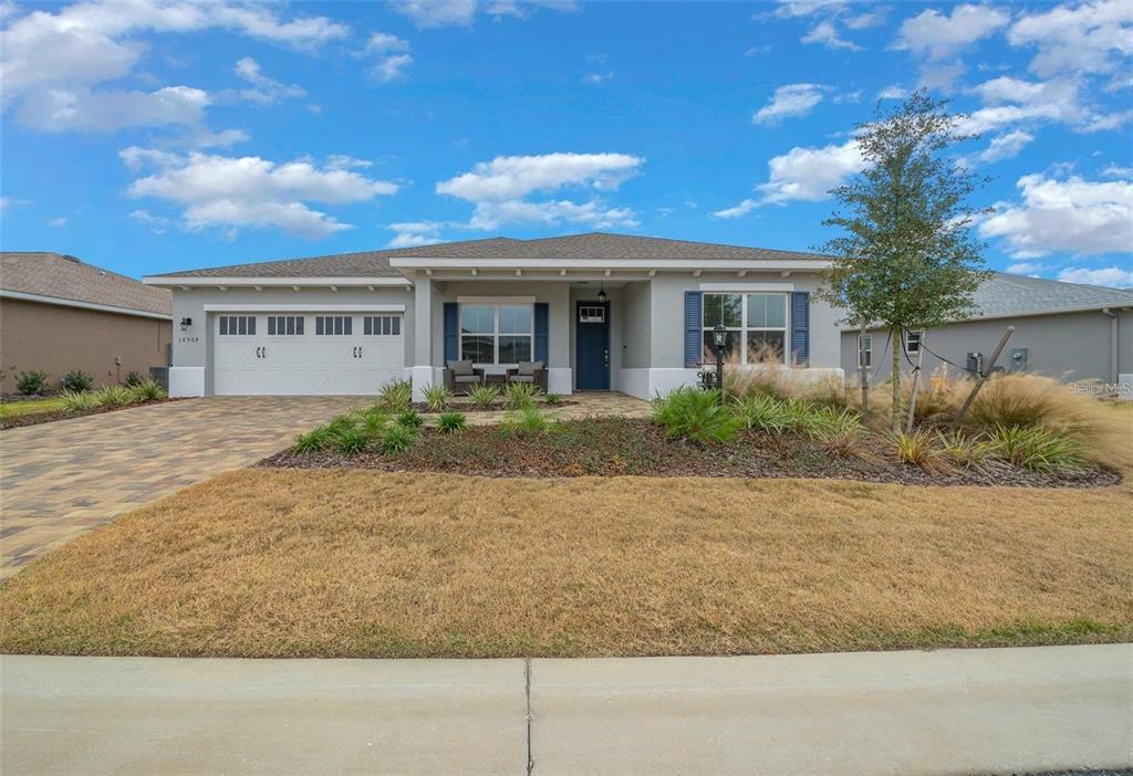 A single-story house with a gray exterior, blue shutters, and a paved driveway — 10564 SW 98TH LANE, OCALA, FL
