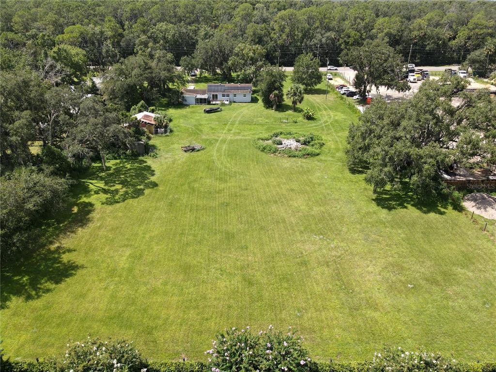 An aerial view shows a large grassy lot with a house and several trees — 6043 S ORANGE BLOSSOM TRAIL, DAVENPORT, FL