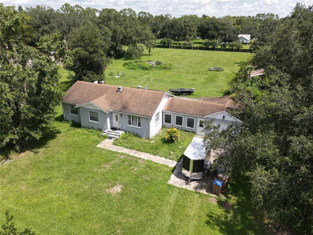 An aerial view of a single-story house with a brown roof and a large grassy yard — 6043 S ORANGE BLOSSOM TRAIL, DAVENPORT, FL