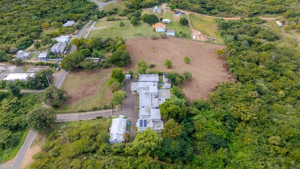An aerial view shows a flat-roofed house with a long driveway surrounded by dense vegetation — D8 PUERTO REAL REMANENTE, VIEQUES, PR