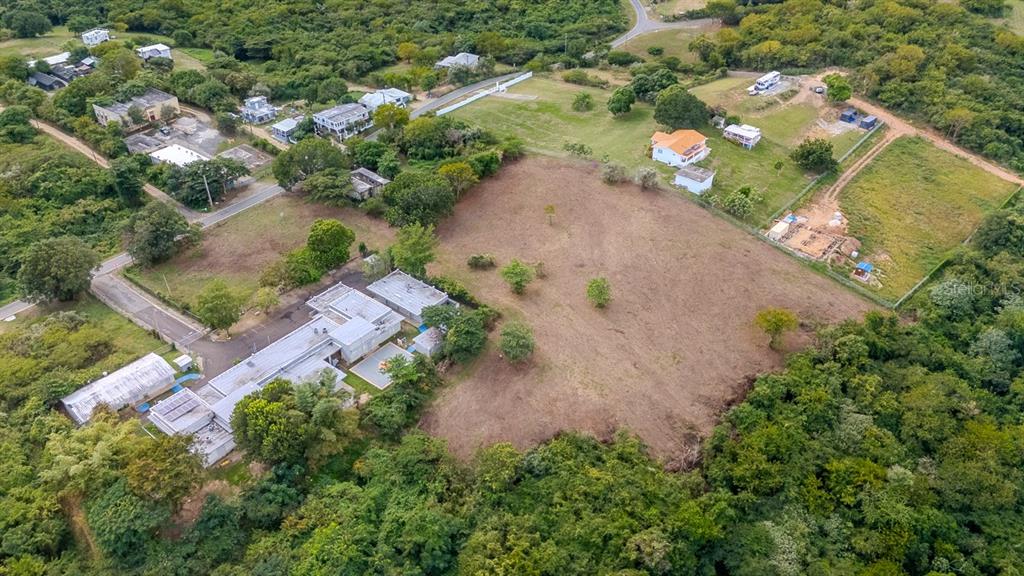 An aerial view shows a large, cleared plot of land surrounded by trees and houses — D8 PUERTO REAL REMANENTE, VIEQUES, PR