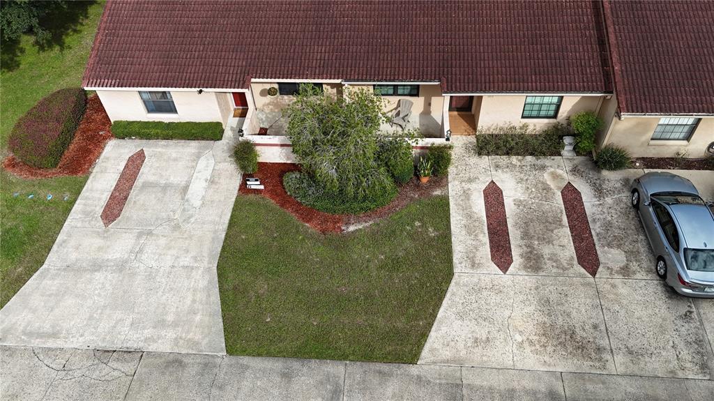 An aerial view shows two adjacent residential units with concrete driveways, a shared lawn, and landscaping — 1915 SW 34TH COURT, OCALA, FL