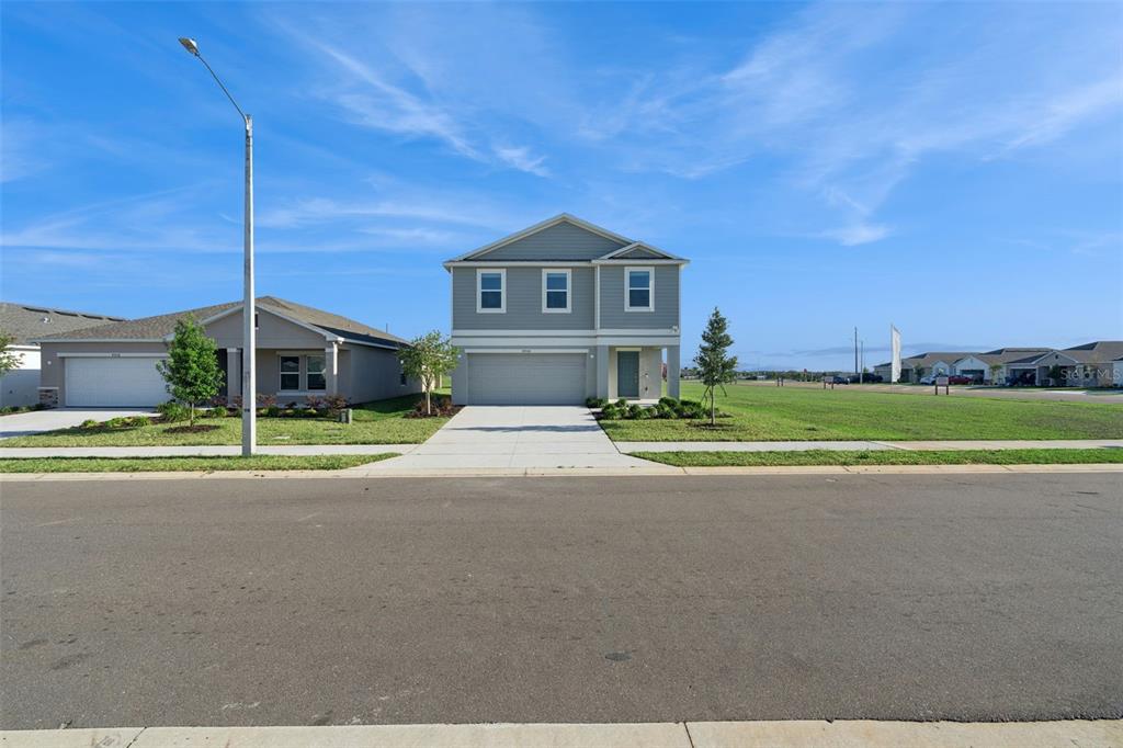A two-story suburban house with a gray exterior, a two-car garage, and a concrete driveway — 4904 BLUEBELL COURT, HAINES CITY, FL