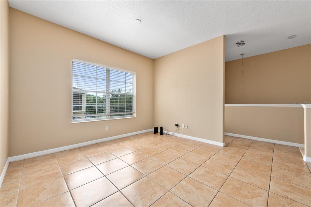 An empty room with beige walls, tile flooring, and a window with white blinds — 7531 PELLHAM WAY UNIT 77, KISSIMMEE, FL
