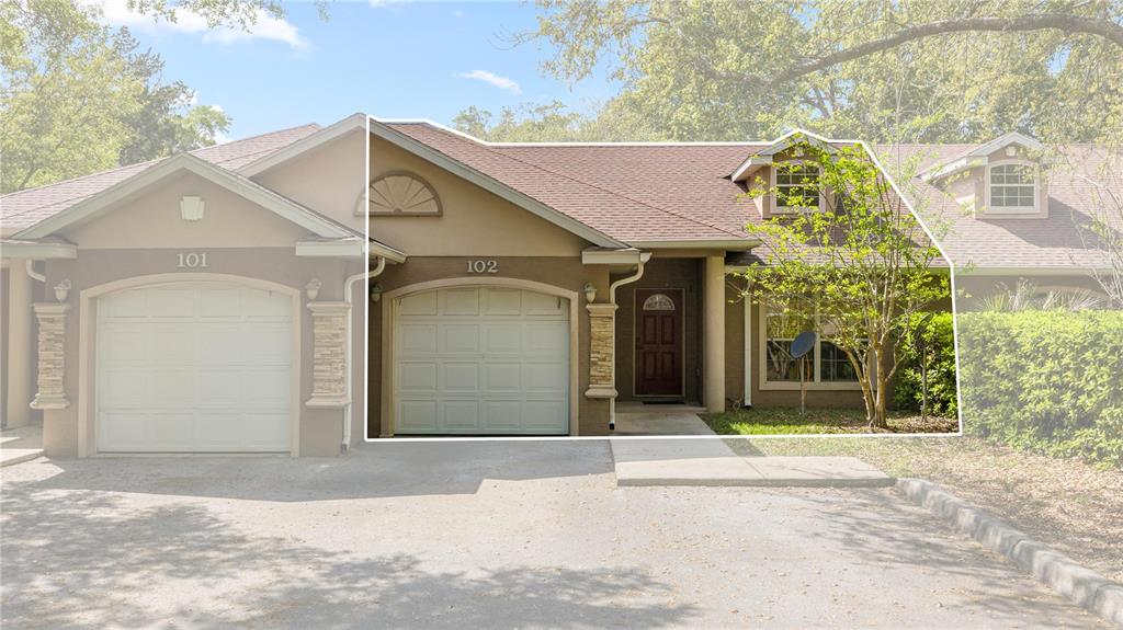 The exterior view shows a single-story residential unit with a garage and a front entrance — 2635 NE 7TH STREET UNIT 102, OCALA, FL
