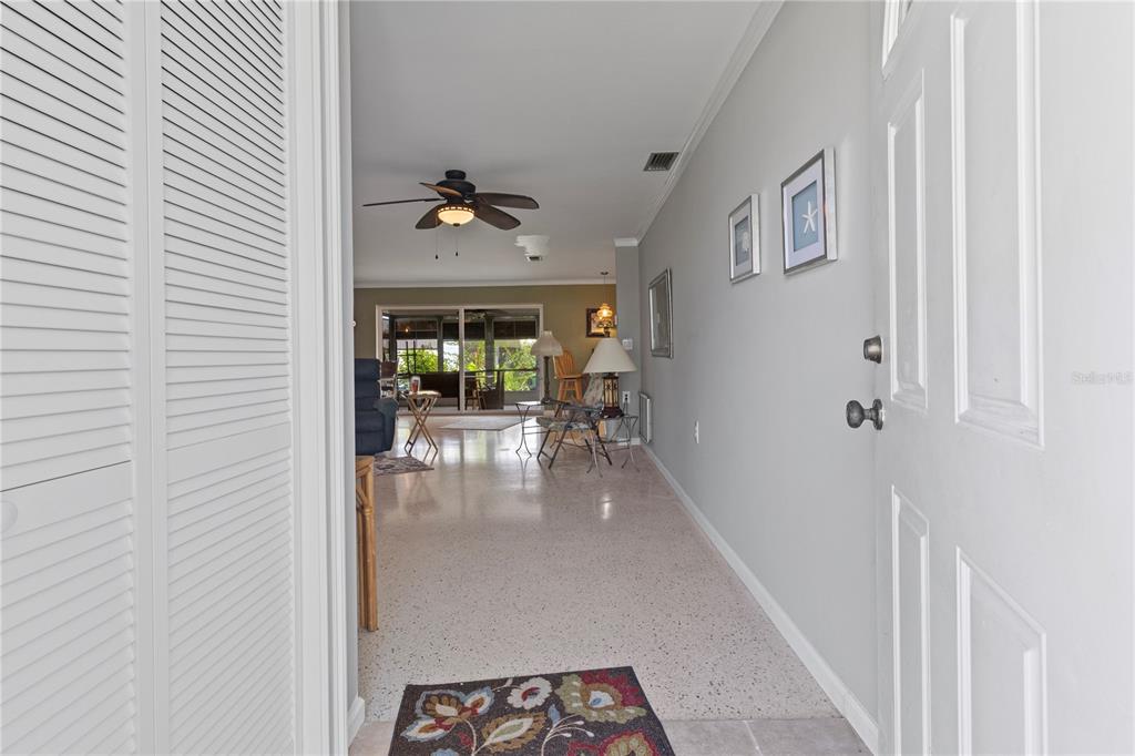 An entryway leads into a living room with terrazzo flooring and a ceiling fan — 4020 PALM DRIVE, PUNTA GORDA, FL