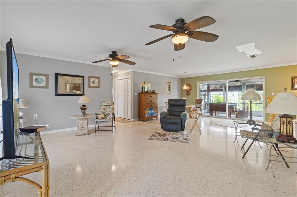 A spacious living room features light-colored terrazzo flooring, two ceiling fans, and a sliding glass door — 4020 PALM DRIVE, PUNTA GORDA, FL