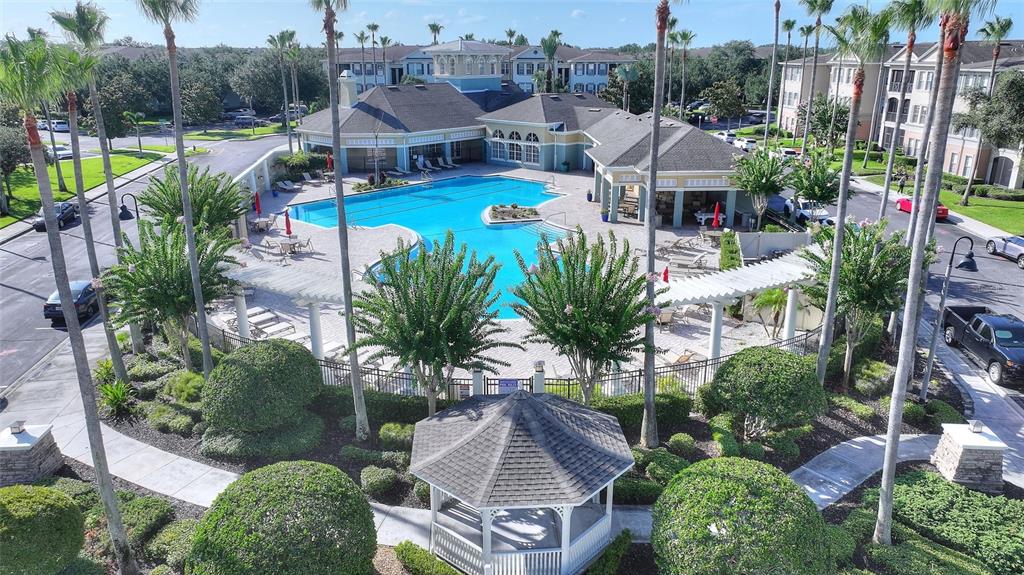 An aerial view of a community swimming pool area with a gazebo and surrounding landscaping — 11564 MIZZON DRIVE UNIT 923, WINDERMERE, FL