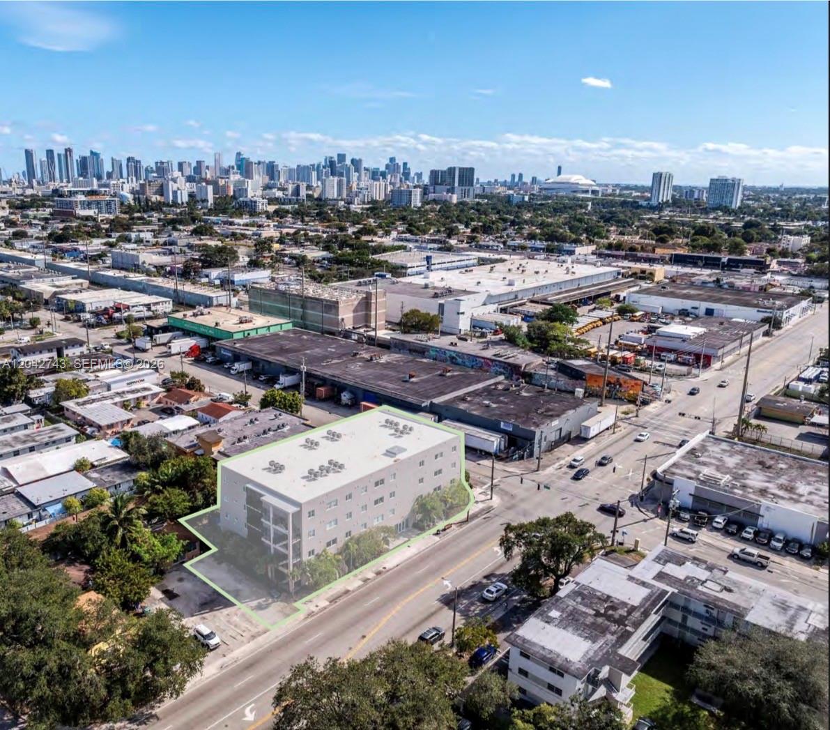An aerial view shows a multi-story apartment building highlighted in green near a city skyline — 2311 NW 22nd Ave, Miami FL 33142, MIAMI, FL