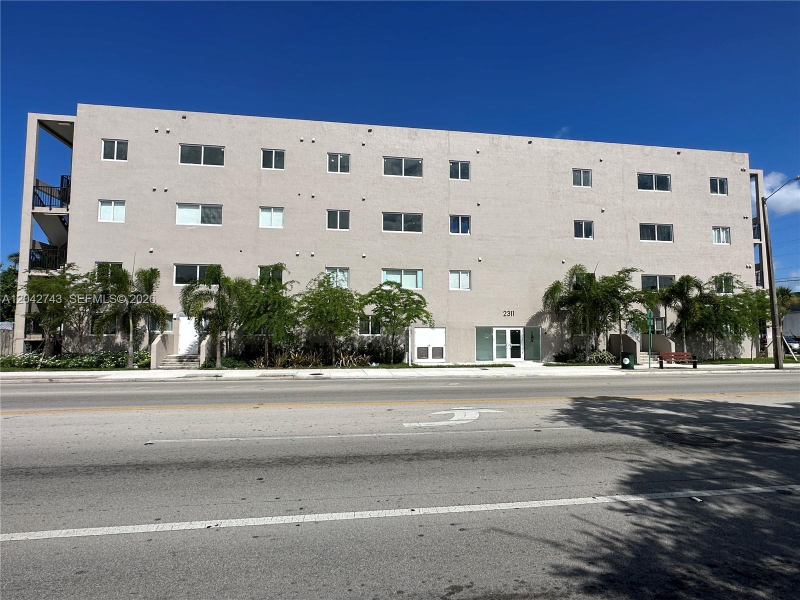 A four-story beige apartment building with a street-level entrance and exterior stairwell — 2311 NW 22nd Ave, Miami FL 33142, MIAMI, FL