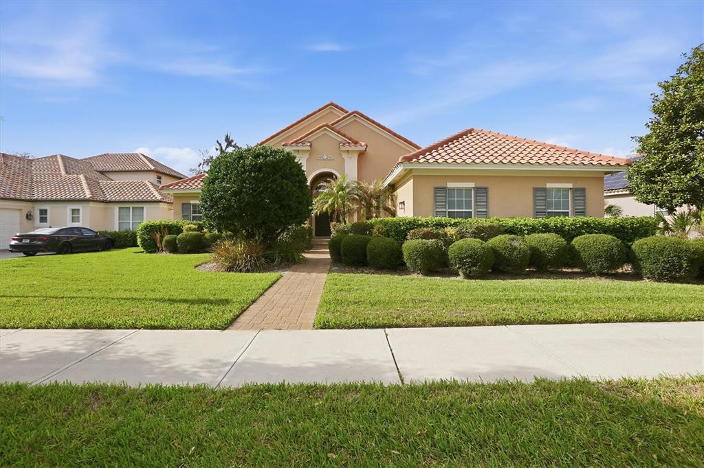 A single-story house with a tile roof, beige stucco exterior, and a manicured front lawn — 13 NEW OAK LEAF DRIVE, PALM COAST, FL