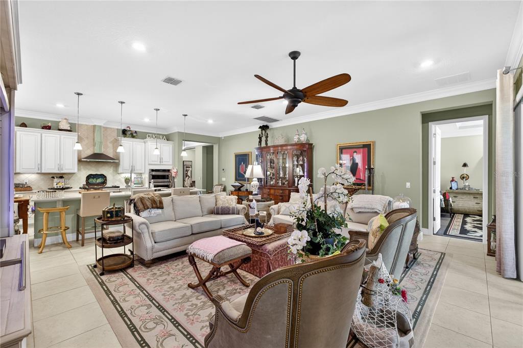A spacious open-concept living room features a kitchen with white cabinets and a ceiling fan — 1651 AMSEL FALLS PARK TERRACE, WINTER GARDEN, FL