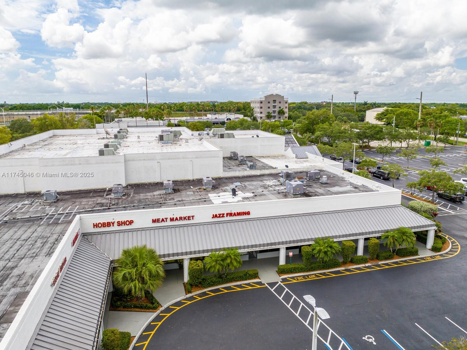 An aerial view shows a commercial strip mall with a parking lot and surrounding trees — 1320 SW 160th Ave, Weston FL 33326, WESTON, FL