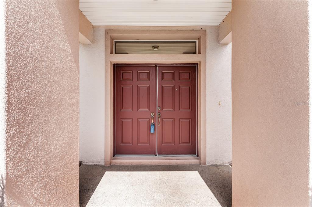 A front entryway features a double door with a transom window between two stucco columns — 12947 SE 97TH TERRACE ROAD, SUMMERFIELD, FL