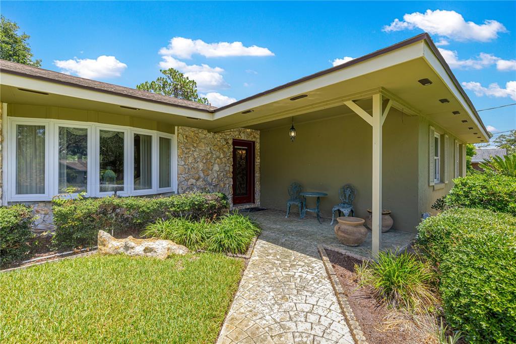 A single-story house exterior features a stone facade, a covered porch, and a stone walkway — 3963 SE 15TH STREET, OCALA, FL