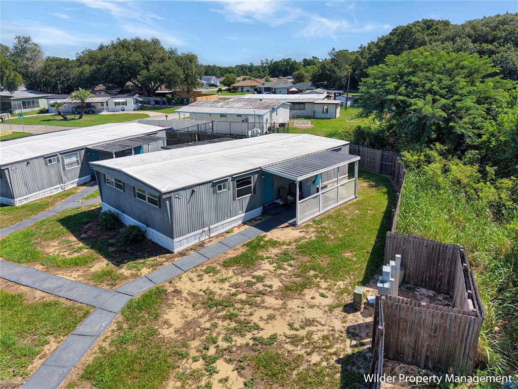 An elevated view shows a gray mobile home with a covered porch and fenced yard — 26 FOREST DRIVE UNIT 32 A, DAVENPORT, FL