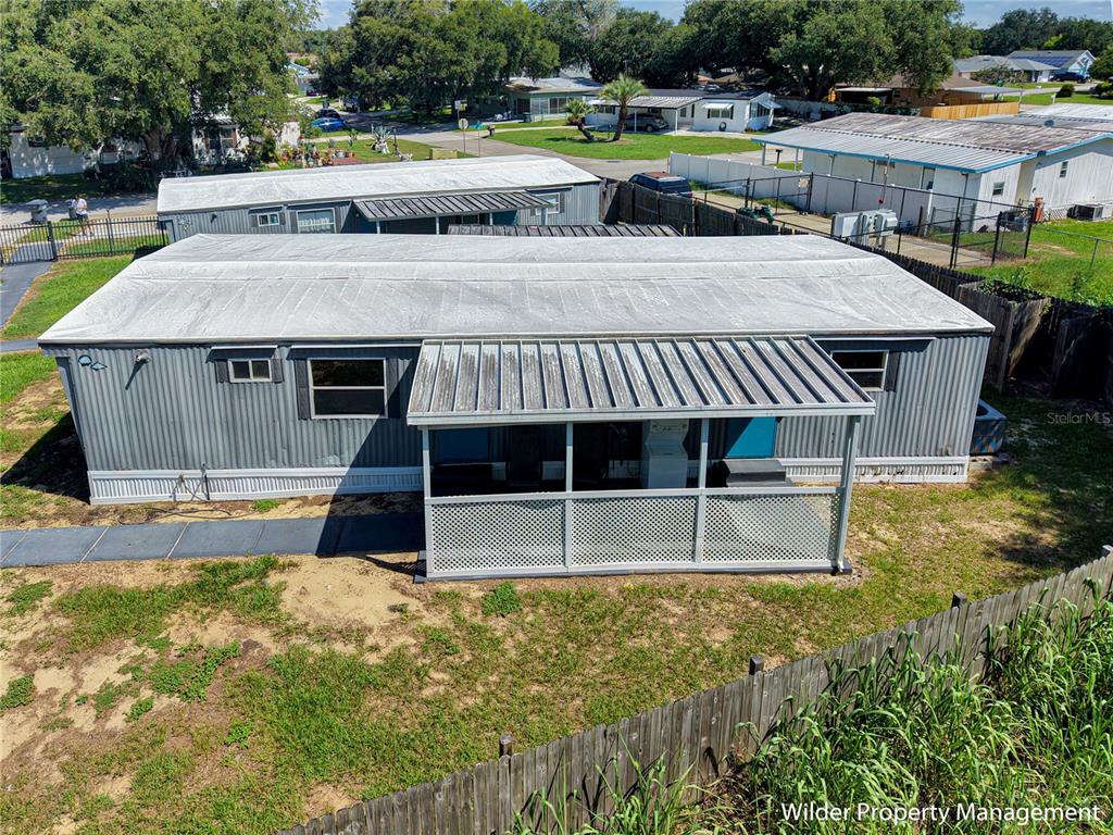 An elevated view of a gray mobile home with a screened-in porch and metal roof — 26 FOREST DRIVE UNIT 32 A, DAVENPORT, FL