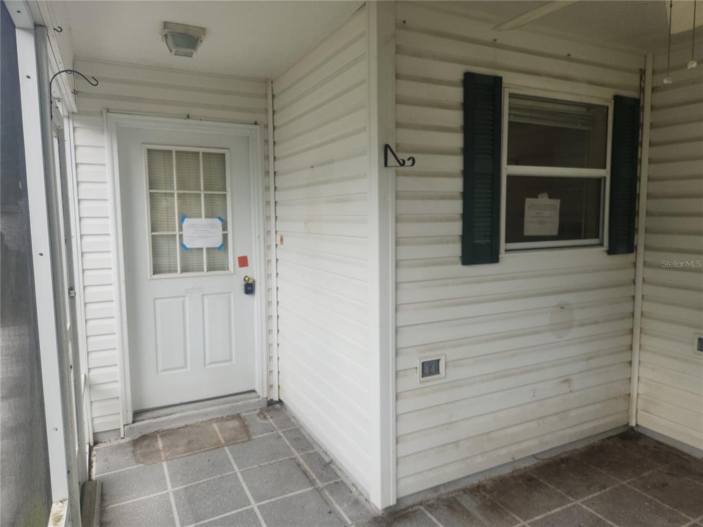 A white door with a window and a small porch with tiled flooring — 17449 SE 81ST NEWBERRY COURT, THE VILLAGES, FL
