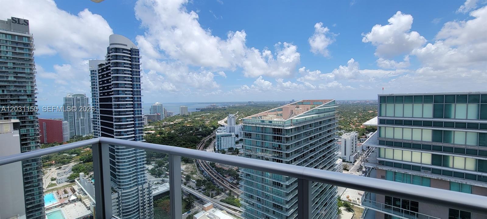 A high-angle view from a balcony overlooking a city skyline and distant water — 1100 S Miami Ave # 4105, Miami FL 33130, MIAMI, FL