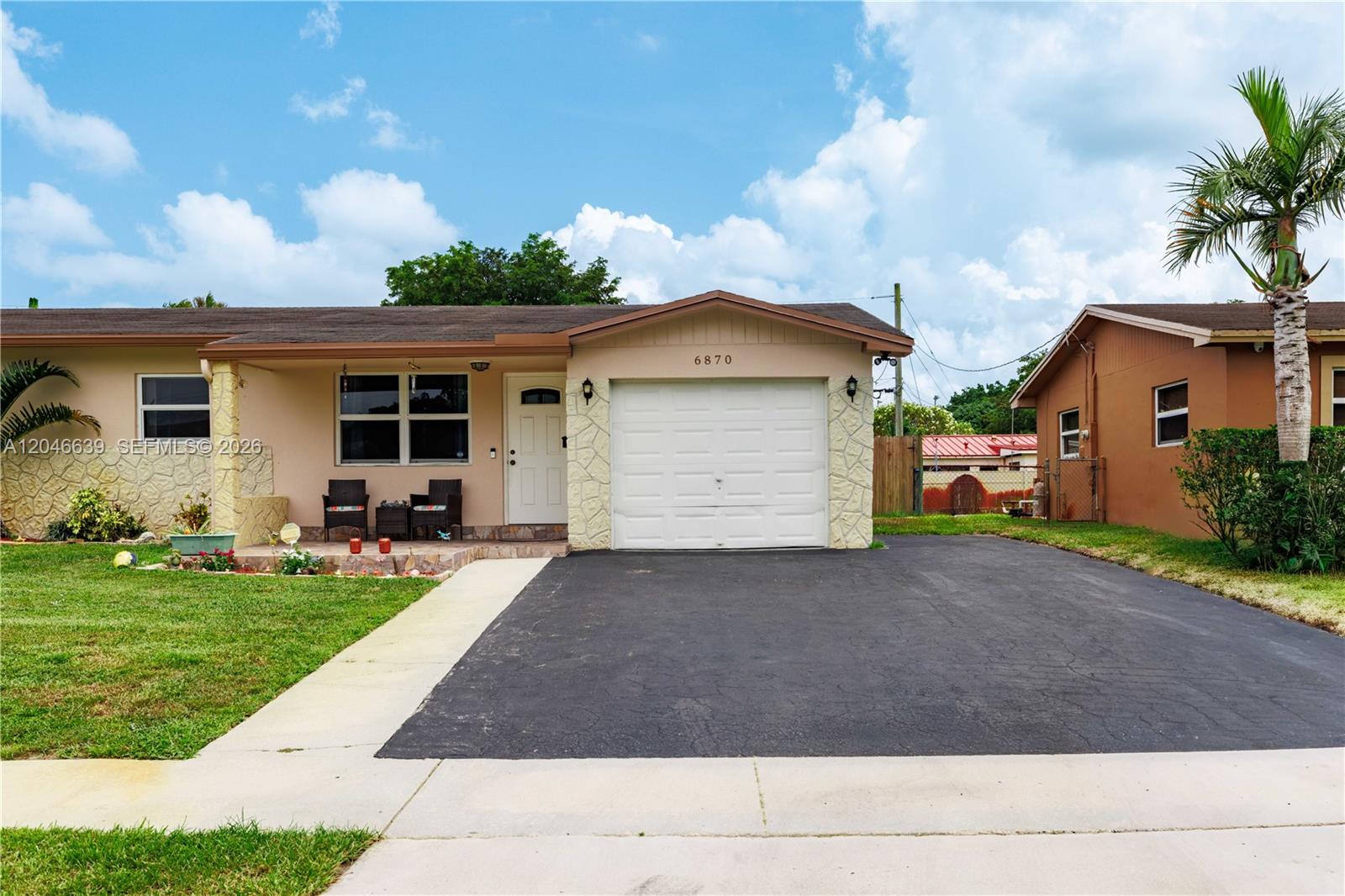 A single-story house features a white garage, a paved driveway, and a small front porch — 6870 Pershing St, Hollywood FL 33024, HOLLYWOOD, FL
