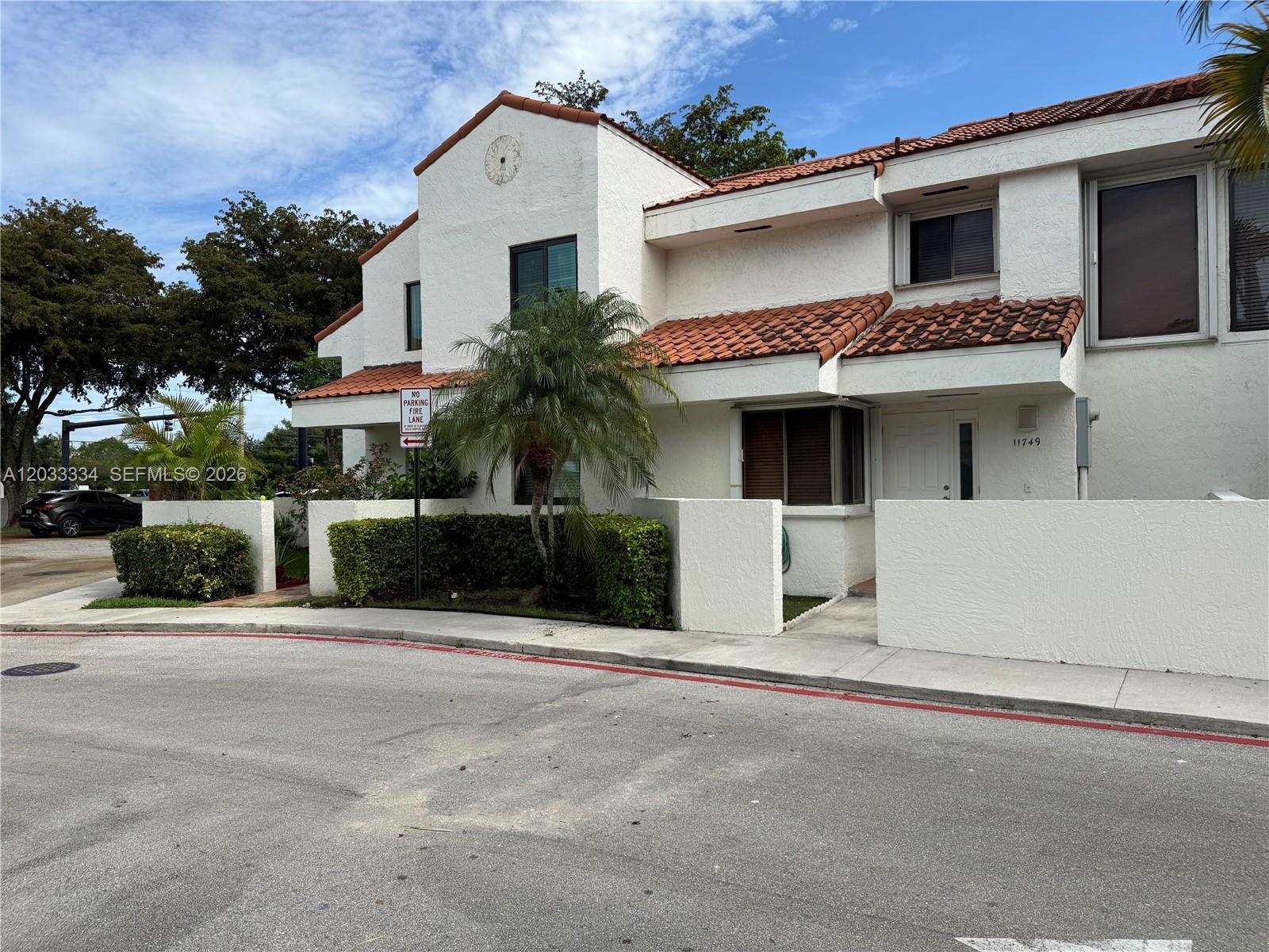 A two-story white stucco townhouse with a red tile roof and a small front courtyard — 11749 Terra Bella Blvd, Plantation FL 33325, PLANTATION, FL