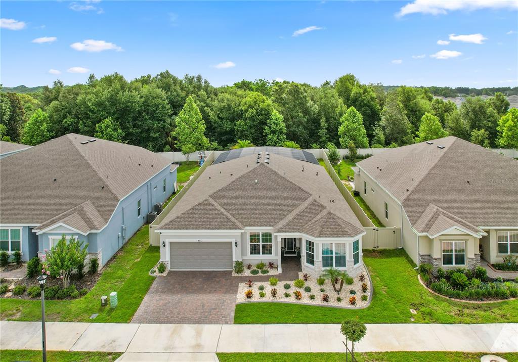 An aerial view shows a single-story house with a paved driveway and a screened-in patio — 4212 WINDING PINES DRIVE, APOPKA, FL