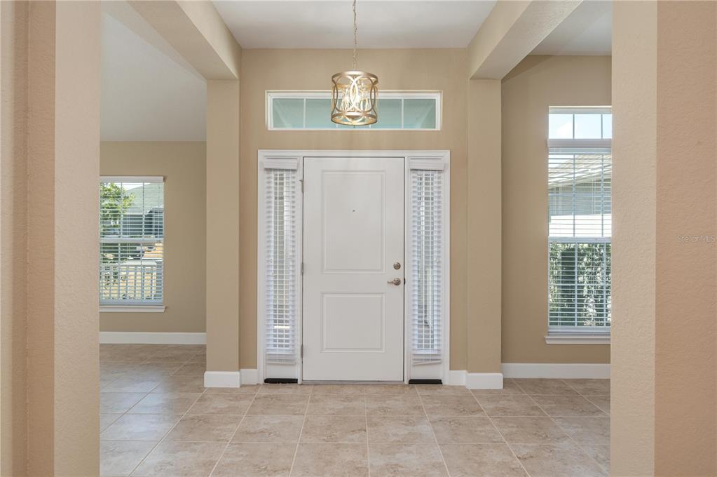 A tiled entryway features a white front door with sidelights, a transom window, and a chandelier — 5455 KNIGHTS LANDING DRIVE, LAKELAND, FL