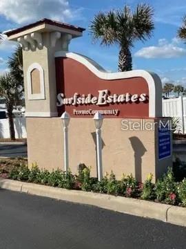A tan stucco monument sign for Surfside Estates stands outdoors with landscaping at its base — 96 MERRIMAC DRIVE, FLAGLER BEACH, FL